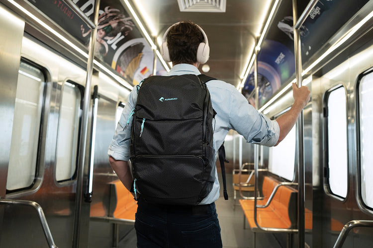 Person with a Alpargali black backpack on a subway train