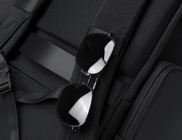 Sunglasses pocket with secure strap on the side of everyday backpack
