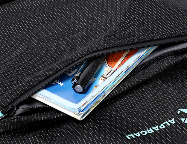 Zipper pocket holding passport and pen in black travel backpack