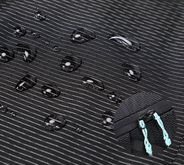 Close-up of water-repellent 210D nylon fabric on the Alpargali sling bag with water droplets showcasing waterproof performance.