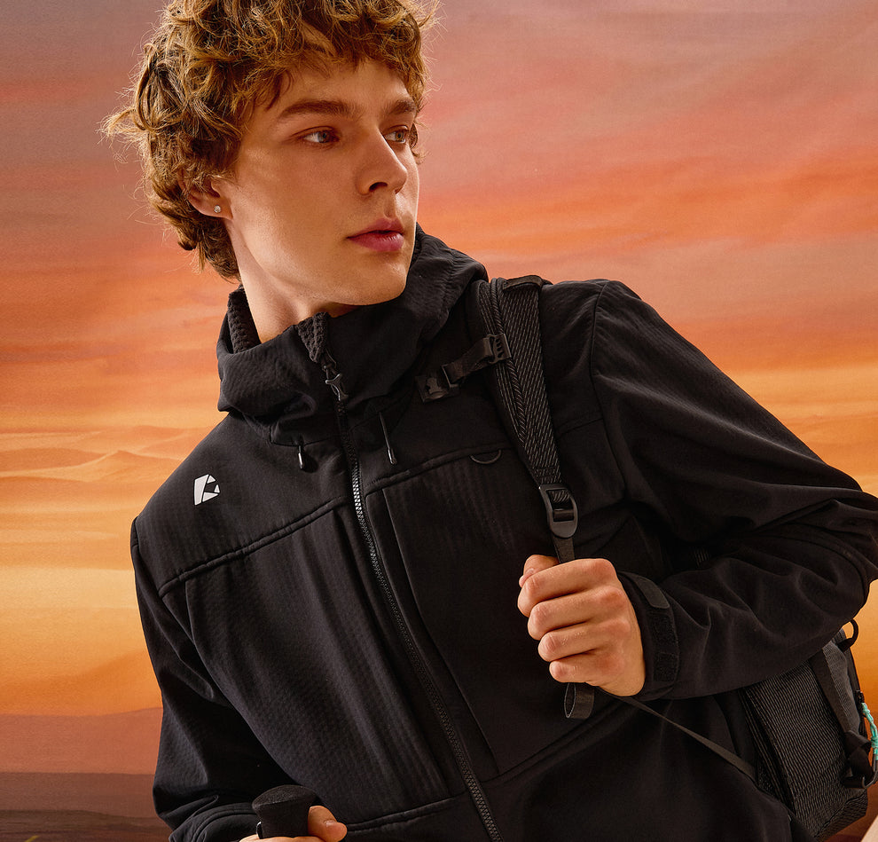 Person wearing a black jacket with a logo against an orange sky