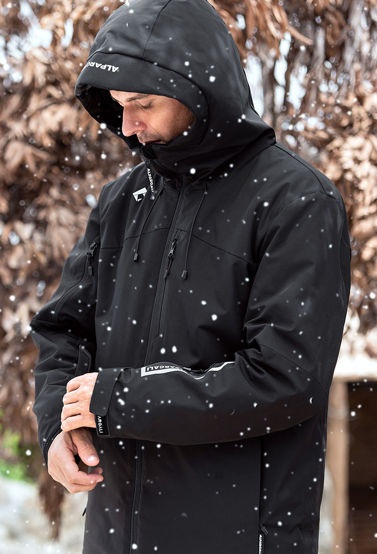 Person wearing a black jacket with a hood in a snowy setting